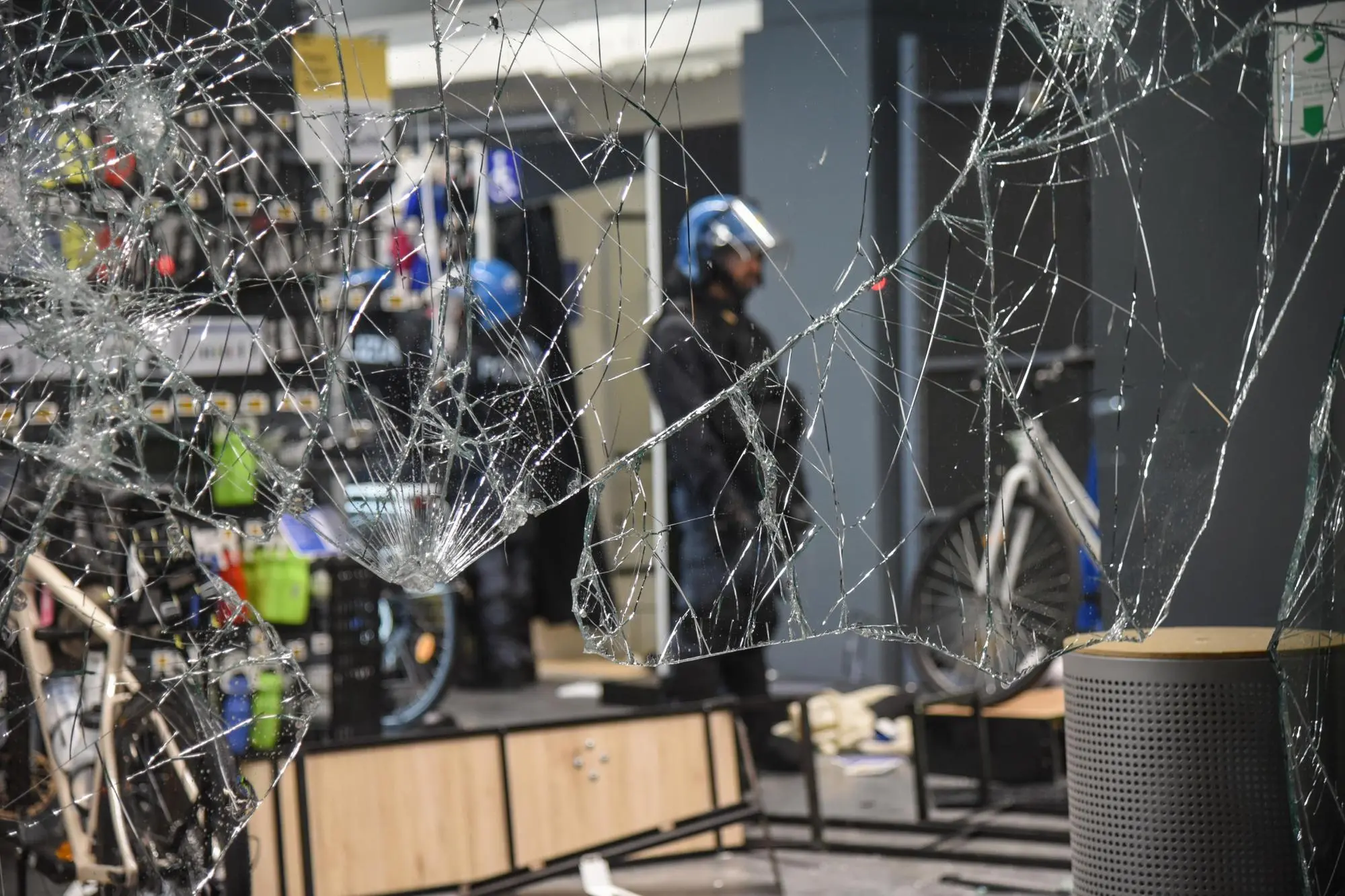 Uno dei negozi distrutti durante gli scontri a Milano (foto Ansa)