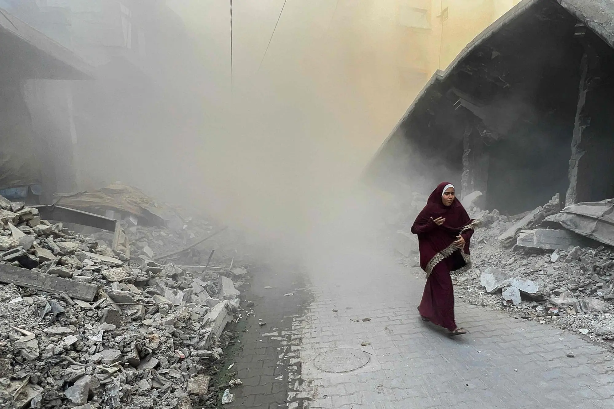 Una donna nella Striscia di Gaza dopo un raid Idf (Ansa-Afp)