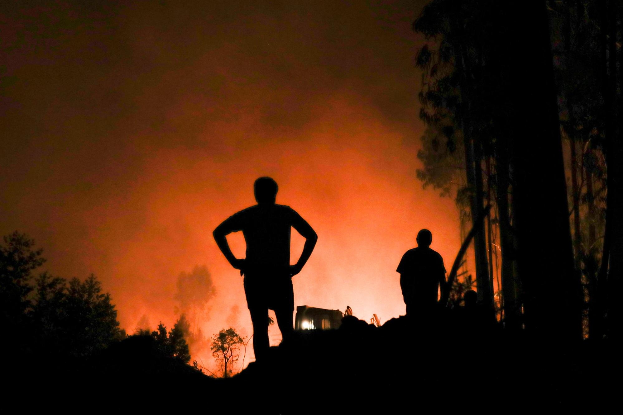 epaselect epa10129889 Inhabitants watch the forest fire in the village of Urqueira, Ourem, Portugal, 19 August 2022. At least 50 people were evacuated from their homes as a precaution on 19 August due to the fire that has been raging since 2:40 pm in the municipality of Ourem, district of Santarem. EPA/PAULO CUNHA