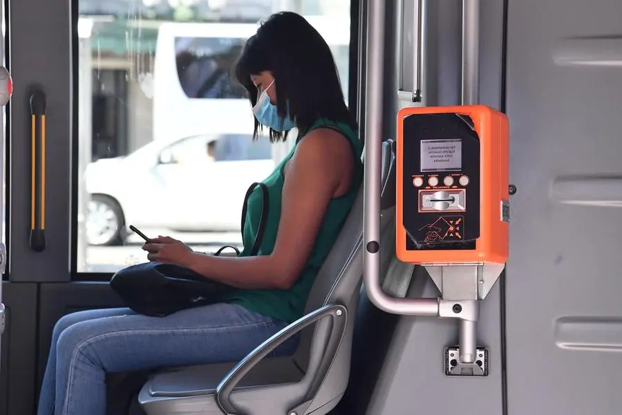 Passeggeri su autobus con la mascherina, da settembre dovrebbero avere anche il green pass per poter salire a bordo. Genova, 25 agosto 2021. ANSA/LUCA ZENNARO