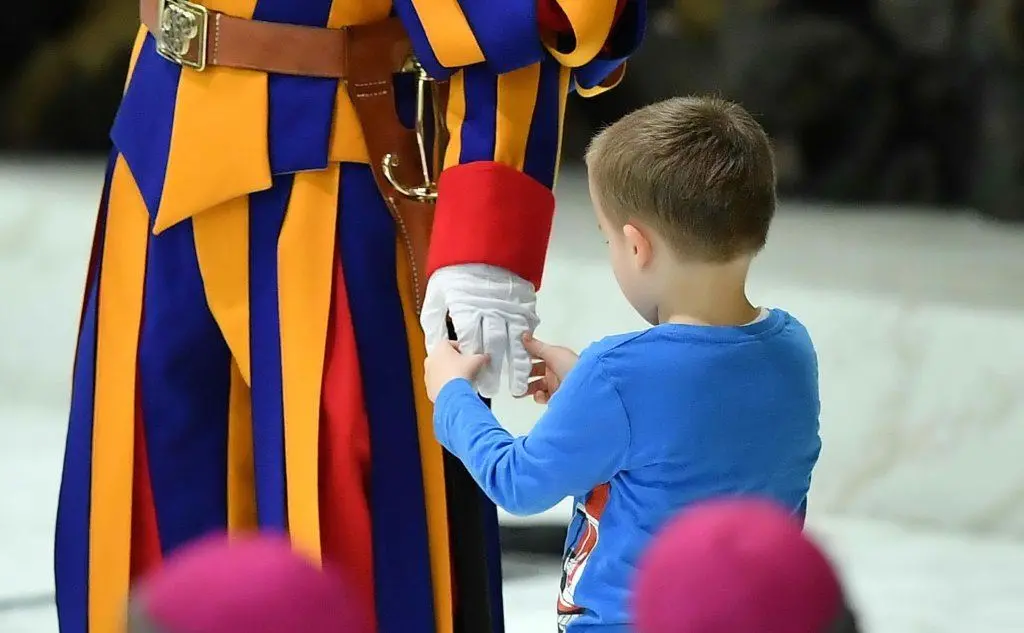 Il piccolo prende la mano alla guardia svizzera (Ansa)