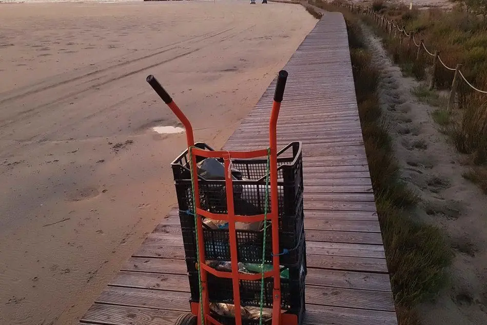 Con i carrelli per riportare la sabbia sul litorale (foto Facebook)