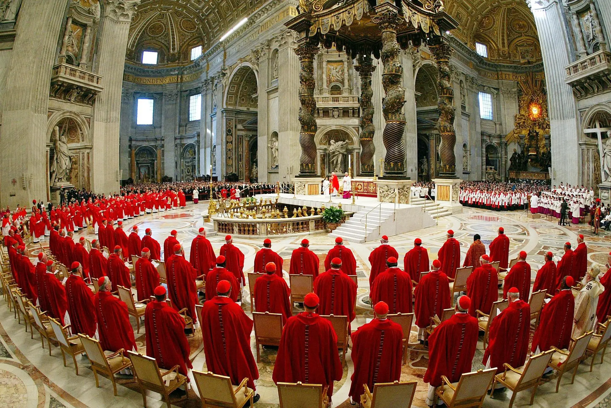 I cardinali vestiti con i paramenti rossi, in piedi davanti l'altare principale della Basilica di San Pietro per partecipare alla messa solenne ''pro eligendo pontifice'', che apre i riti del conclave per l'elezione del successore di Giovanni Paolo II il 18 aprile 2005. ANSA