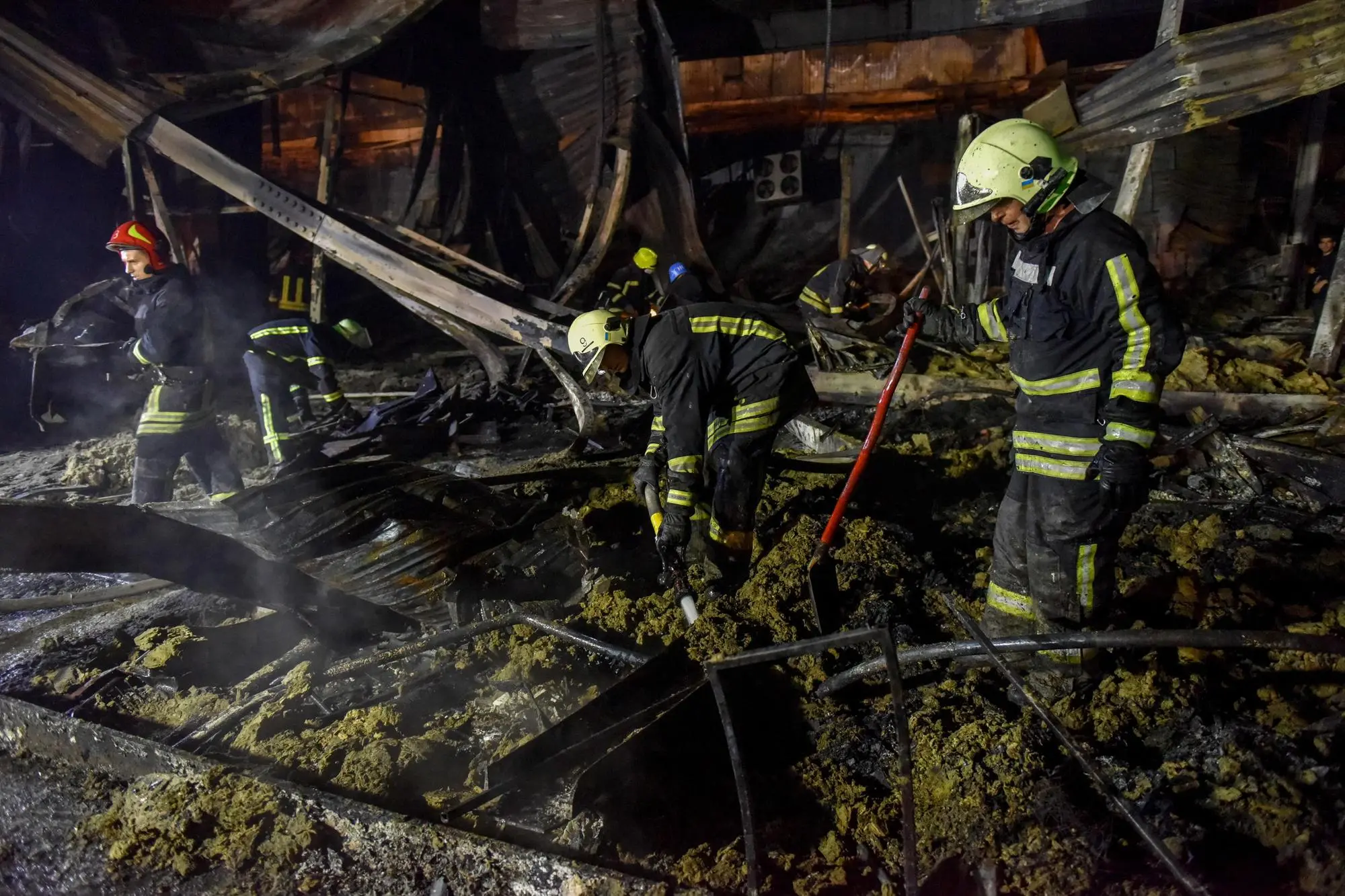 epa10037596 Firefighters clean the rubble of the destroyed Amstor shopping mall in Kremenchuk, Poltava Oblast, Ukraine, 27 June 2022. At least eleven bodies were found dead at the scene, the State Emergency Service (SES) of Ukraine said in a Telegram post, and at least 58 injured following Russian airstrikes on the crowded shopping mall. The one-story building of a shopping center was hit by Russian rockets in the afternoon. EPA/OLEG PETRASYUK