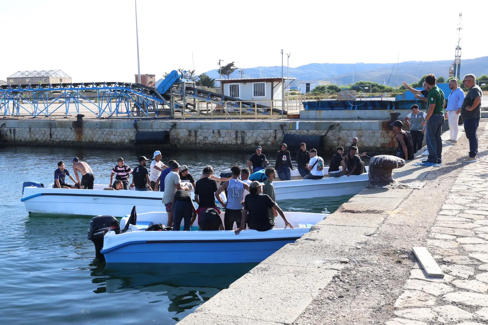 Lo sbarco dei migranti al porto di Sant’Antioco (f. mu.)
