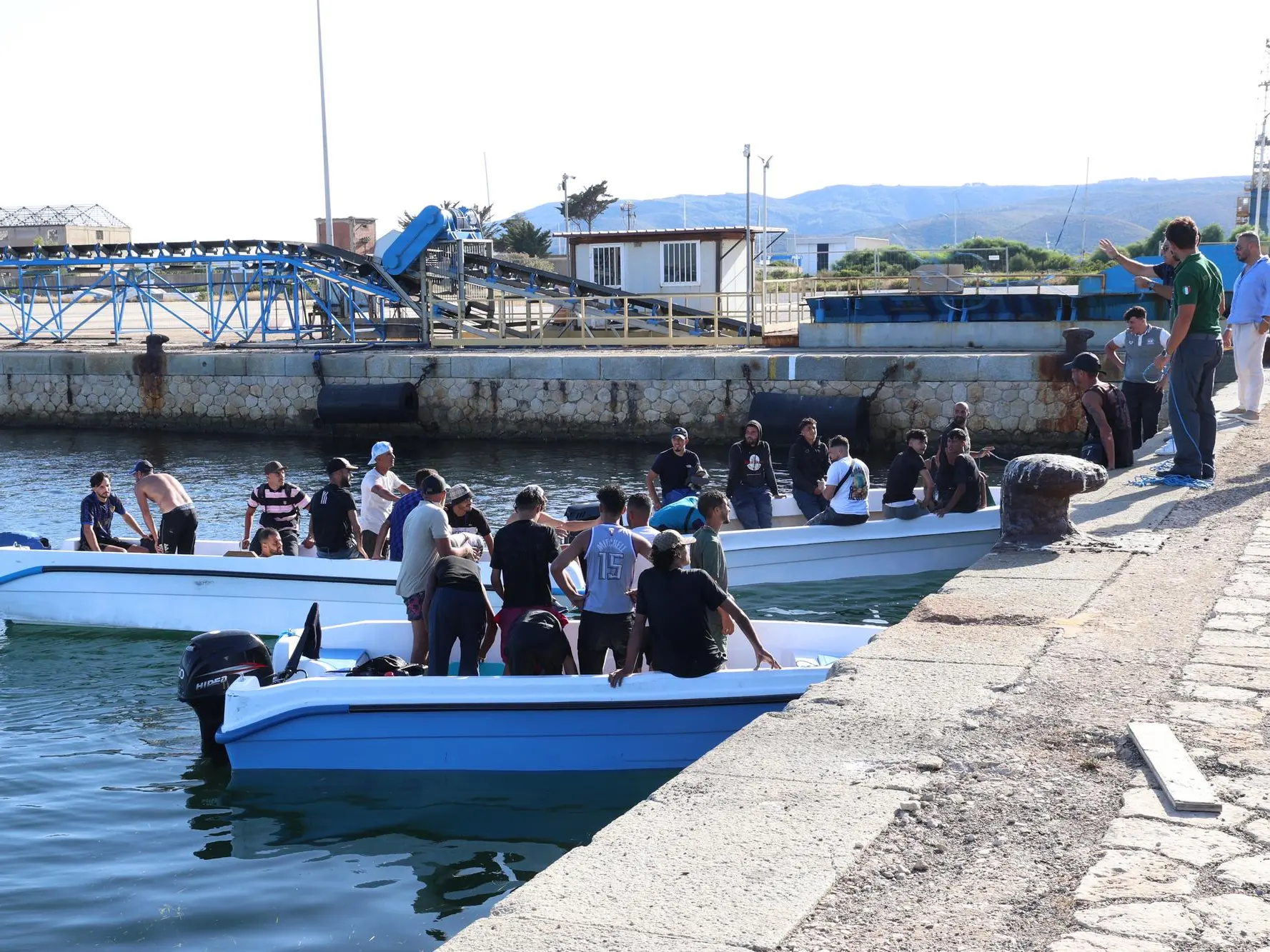 Lo sbarco dei migranti al porto di Sant’Antioco (f. mu.)