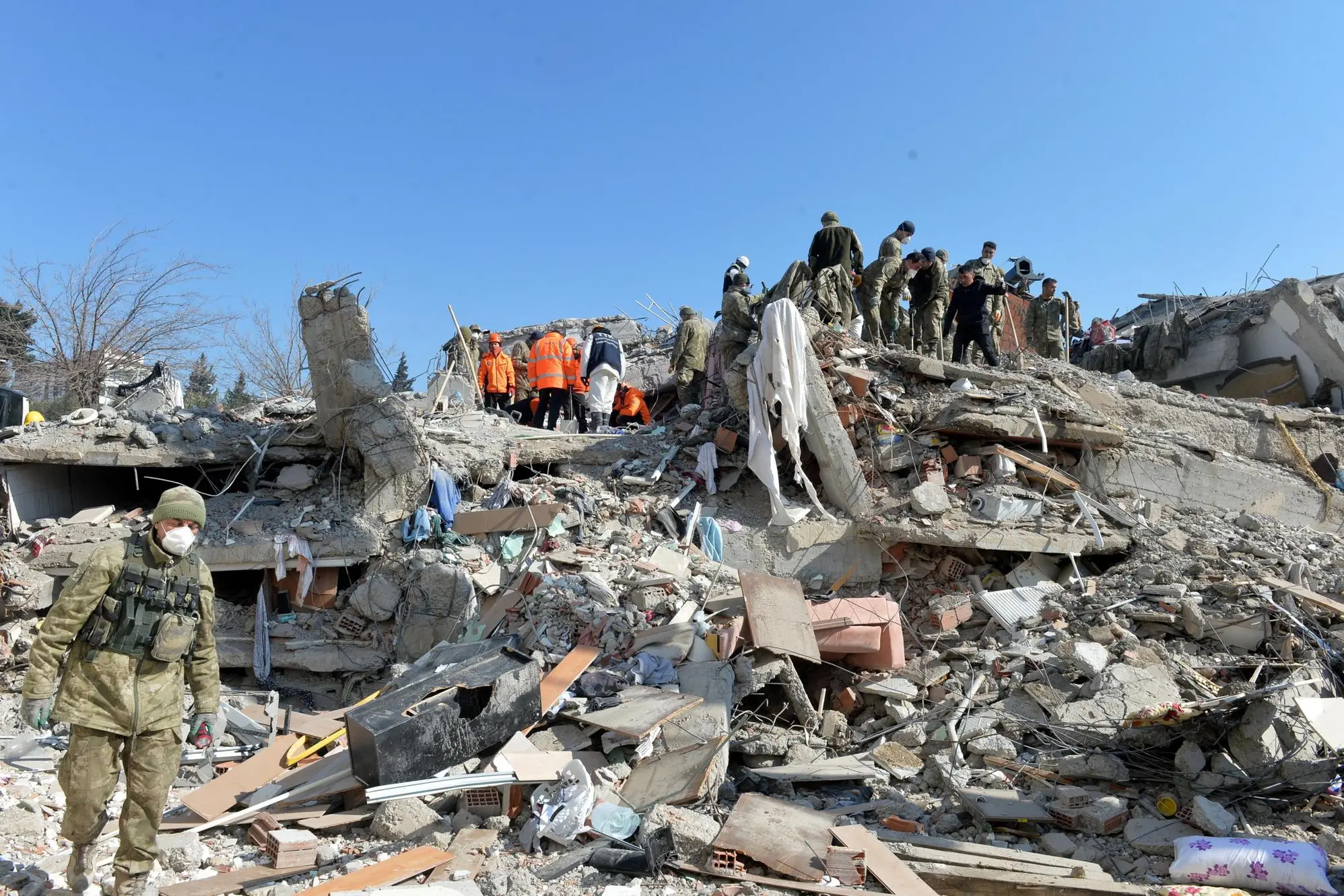 epa10460778 Turkish soldiers search for victims at a collapsed building in the aftermath of a major earthquake in Islahiye district of Gaziantep city, Turkey, 11 February 2023. More than 24,000 people have died and thousands more are injured after two major earthquakes struck southern Turkey and northern Syria on 06 February. Authorities fear the death toll will keep climbing as rescuers look for survivors across the region. EPA/NECATI SAVAS