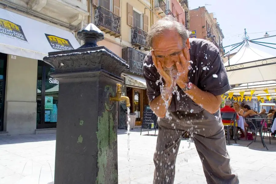 Un uomo si rinfresca a una fontana (Archivio L'Unione Sarda)