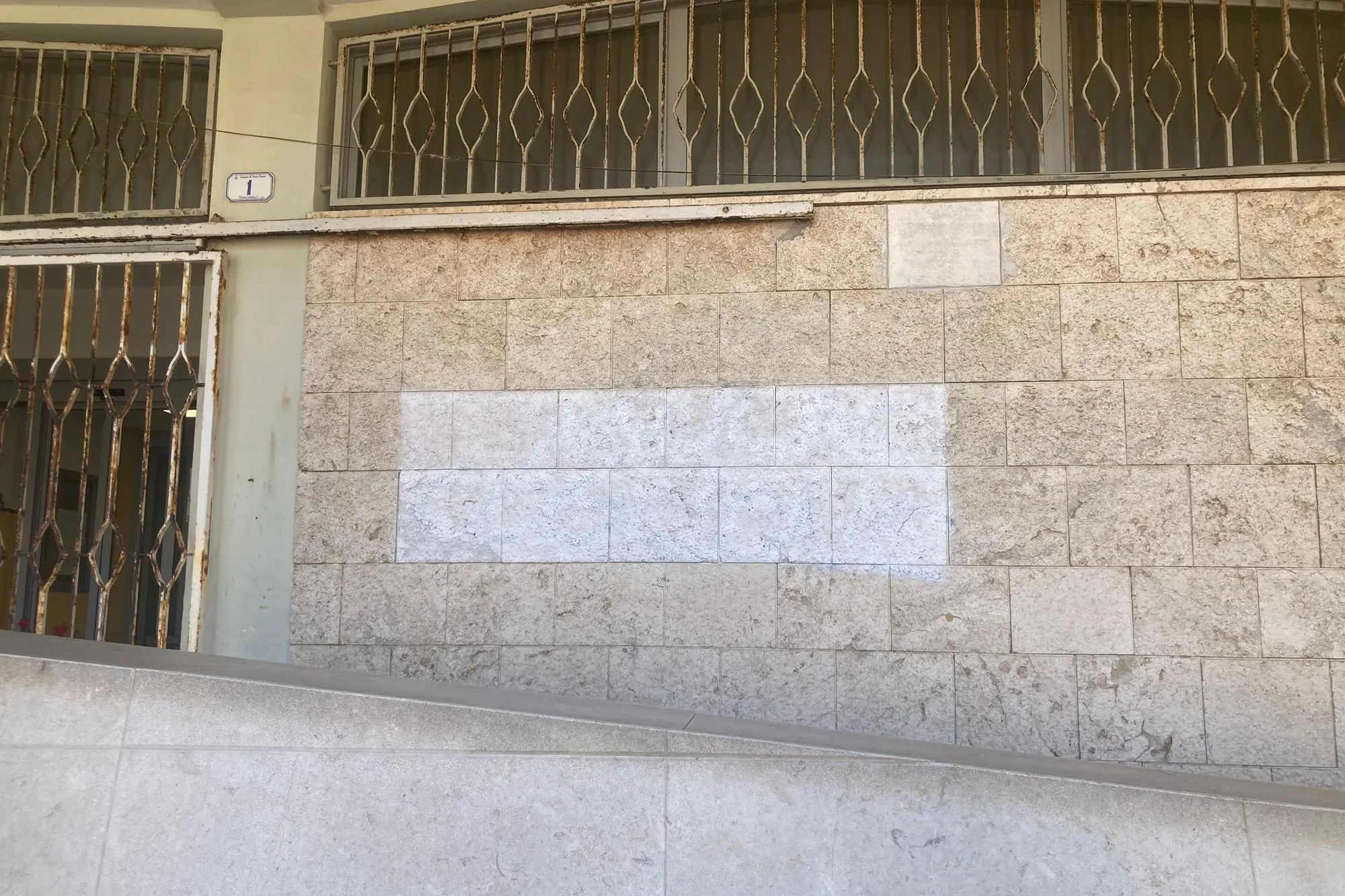 La scritta cancellata sulla facciata del municipio (foto Pala)