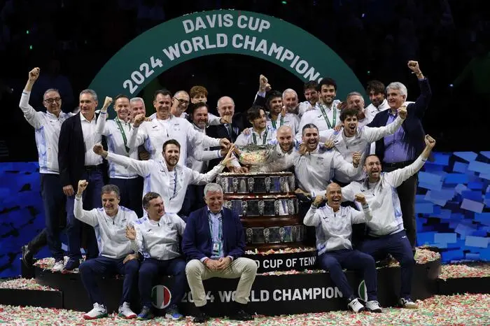 Team Italy celebrate with their trophy after winning the Davis Cup Finals at the Palacio de Deportes Jose Maria Martin Carpena arena in Malaga, southern Spain, on November 24, 2024. (Photo by Thomas COEX / AFP)