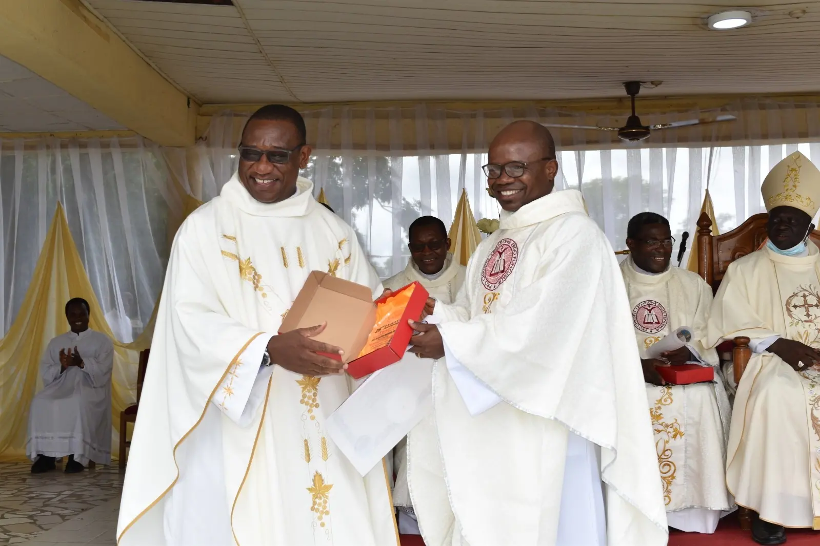 Padre Cletus (a destra nella foto) riceve un dono in occasione dei suoi 25 anni di sacerdozio (foto concessa)