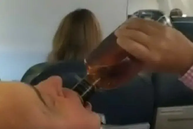 L'uomo beve mentre tutti pregano (fermo immagine da YouTube)