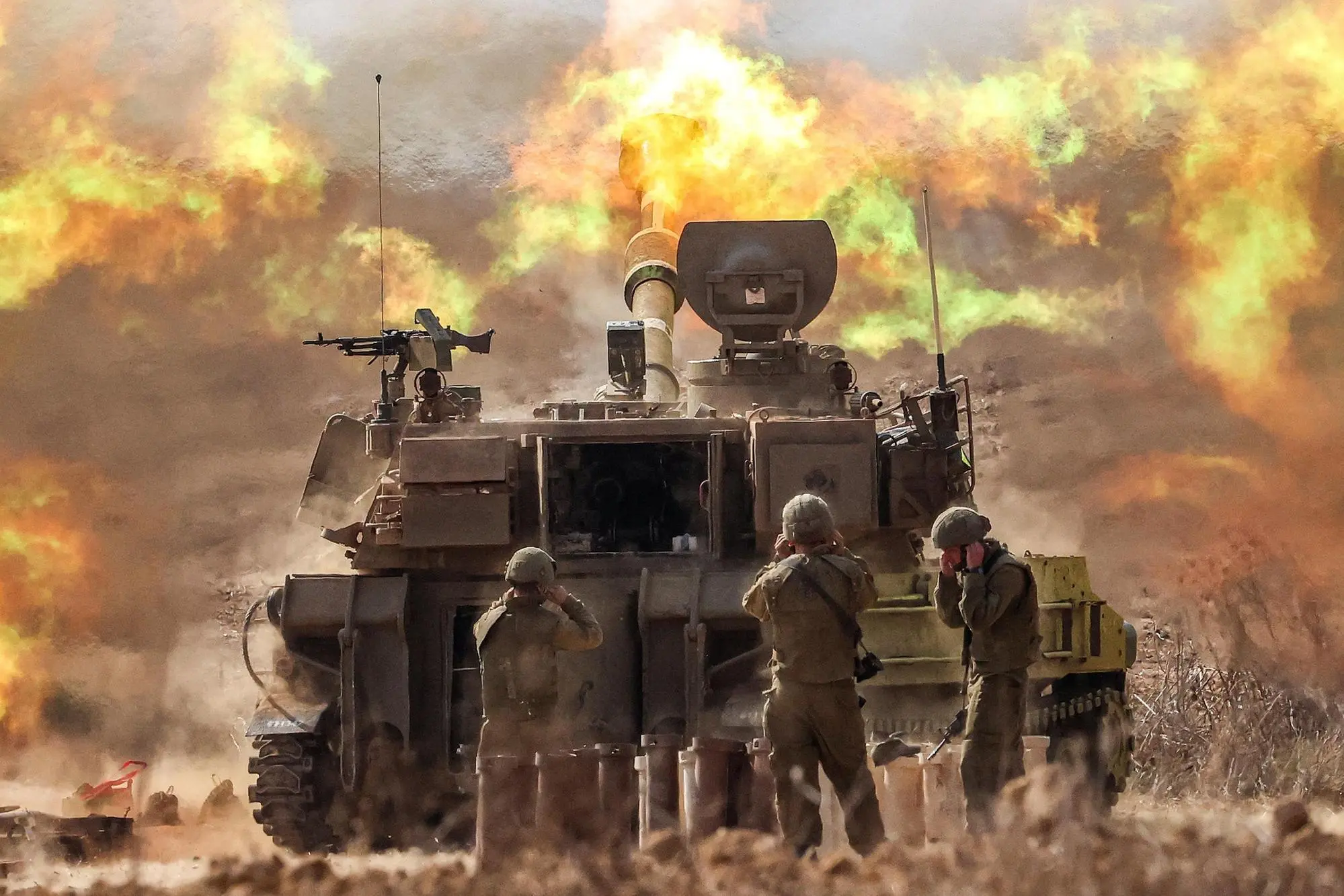 TOPSHOT - An Israeli army self-propelled howitzer fires rounds near the border with Gaza in southern Israel on October 11, 2023. Israel declared war on Hamas on October 8 following a shock land, air, and sea assault by the Gaza-based militant group. The death toll in Israel has surged above 1,200 following the worst attack in the country's 75-year history, while Gaza officials have reported 1000 people killed so far. (Photo by JACK GUEZ / AFP)