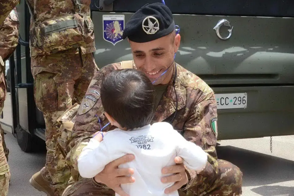 Un militare riabbraccia il figlio all'aeroporto di Alghero (foto Gloria Calvi)