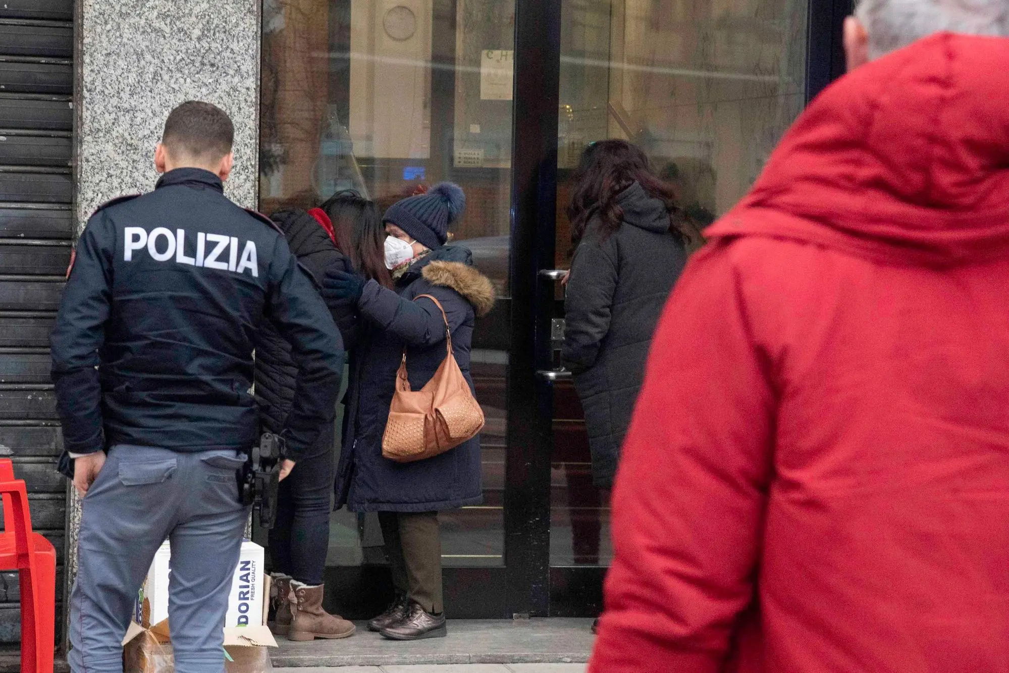 La disperazione della moglie del titolare del bar ucciso, consolato da una passante (Ansa-Epa)