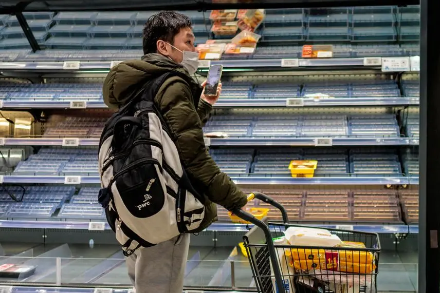 epa09848842 A costumer buys food in a half-empty grocery store, in Shanghai, China, 25 March 2022. On 25 March 2022, in China, there were reported 1,301 new locally transmitted COVID-19 cases, 3,487 asymptomatic infections according to the National Health Commission. The growth of Shanghai's new cases has stopped under the current prevention strategies, such as rolling type screening, according to Dr Zhang Wenhong, director of the Nacional Centre for Infectious Diseases. Authorities in Shanghai denied online rumours of citywide lockdown that caused panic buying. EPA/ALEX PLAVEVSKI