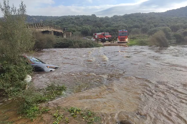 La strada allagata con l'auto sommersa (foto Busia)
