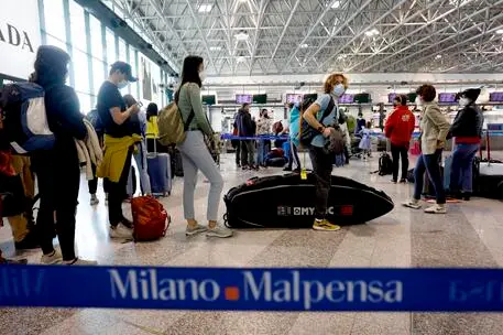 Passeggeri in partenza all'aeroporto di Malpensa (Ansa)