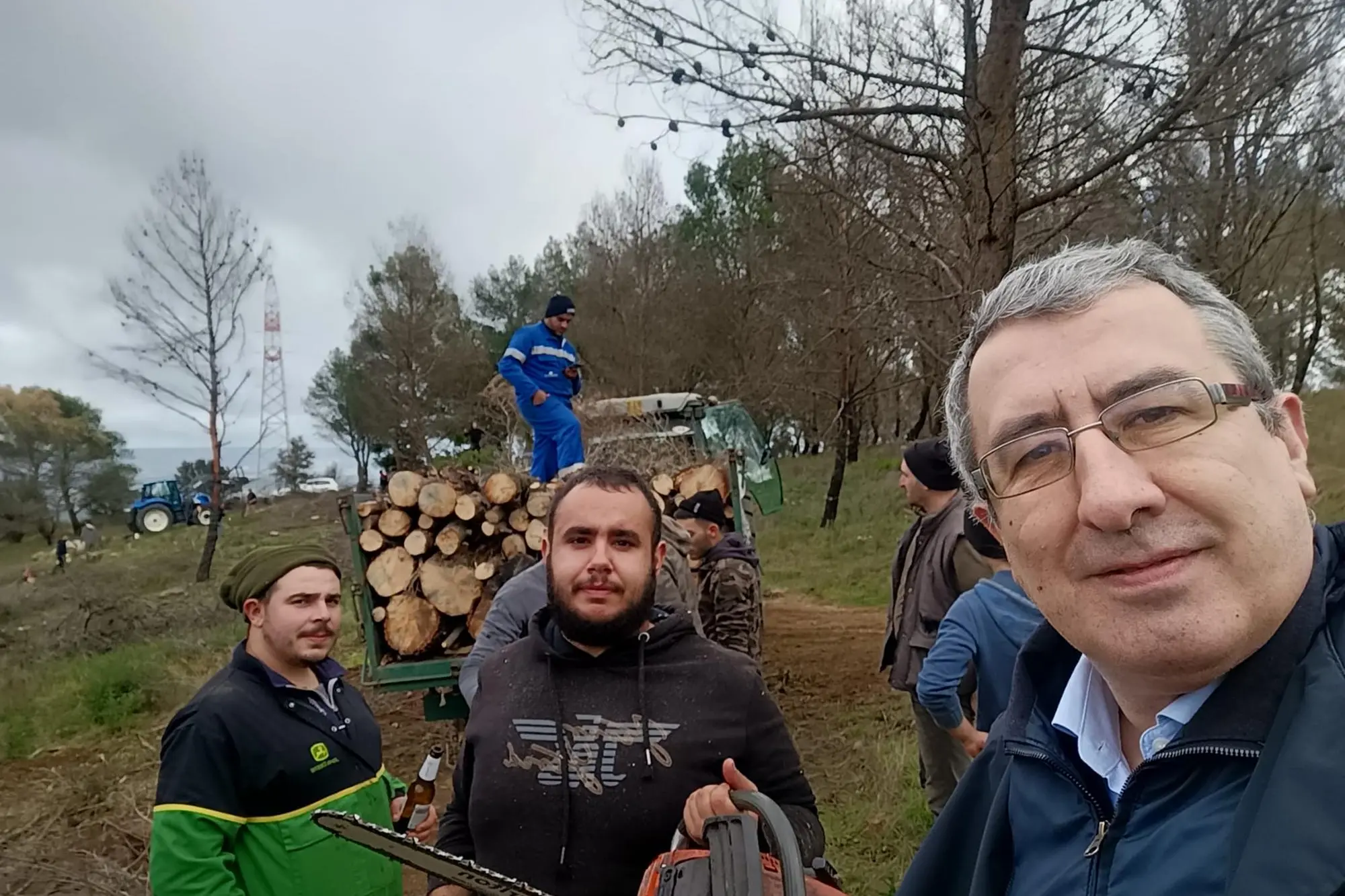 Il sindaco Oppus (a destra) impegnato nella raccolta della legna per S. Sebastiano (foto Sirigu)