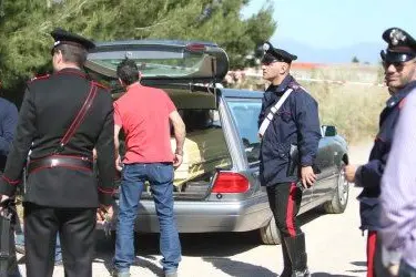 Il cadavere dell'uomo trovato ucciso viene rimosso dagli inquirenti