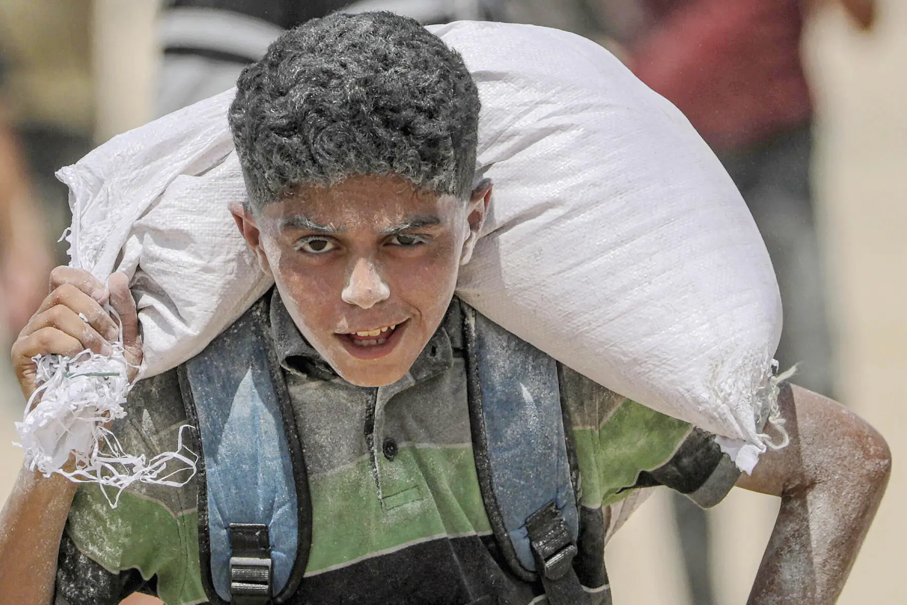 Un bambino palestinese con un sacco di farina (Foto simbolo)