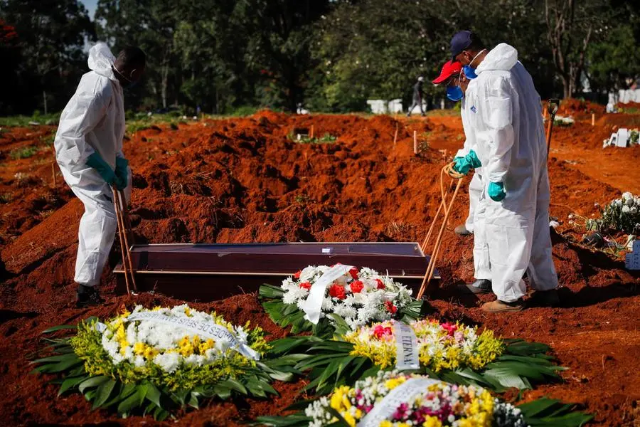 Due addetti al cimitero seppelliscono la salma di una vittima di Covid a San Paolo del Brasile (EPA/FERNANDO BIZERRA)