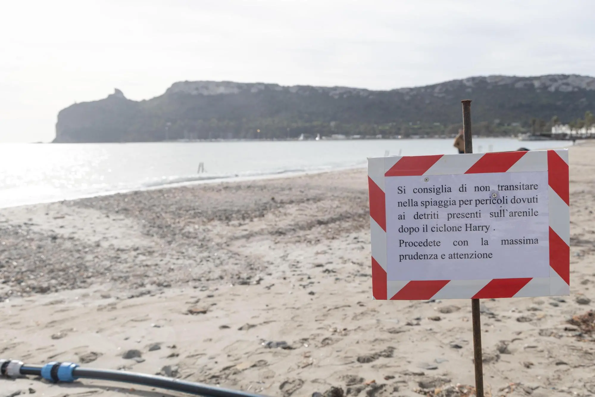 Un cartello nella spiaggia del Poetto di Cagliari dopo il passaggio del ciclone Harry (Ansa)