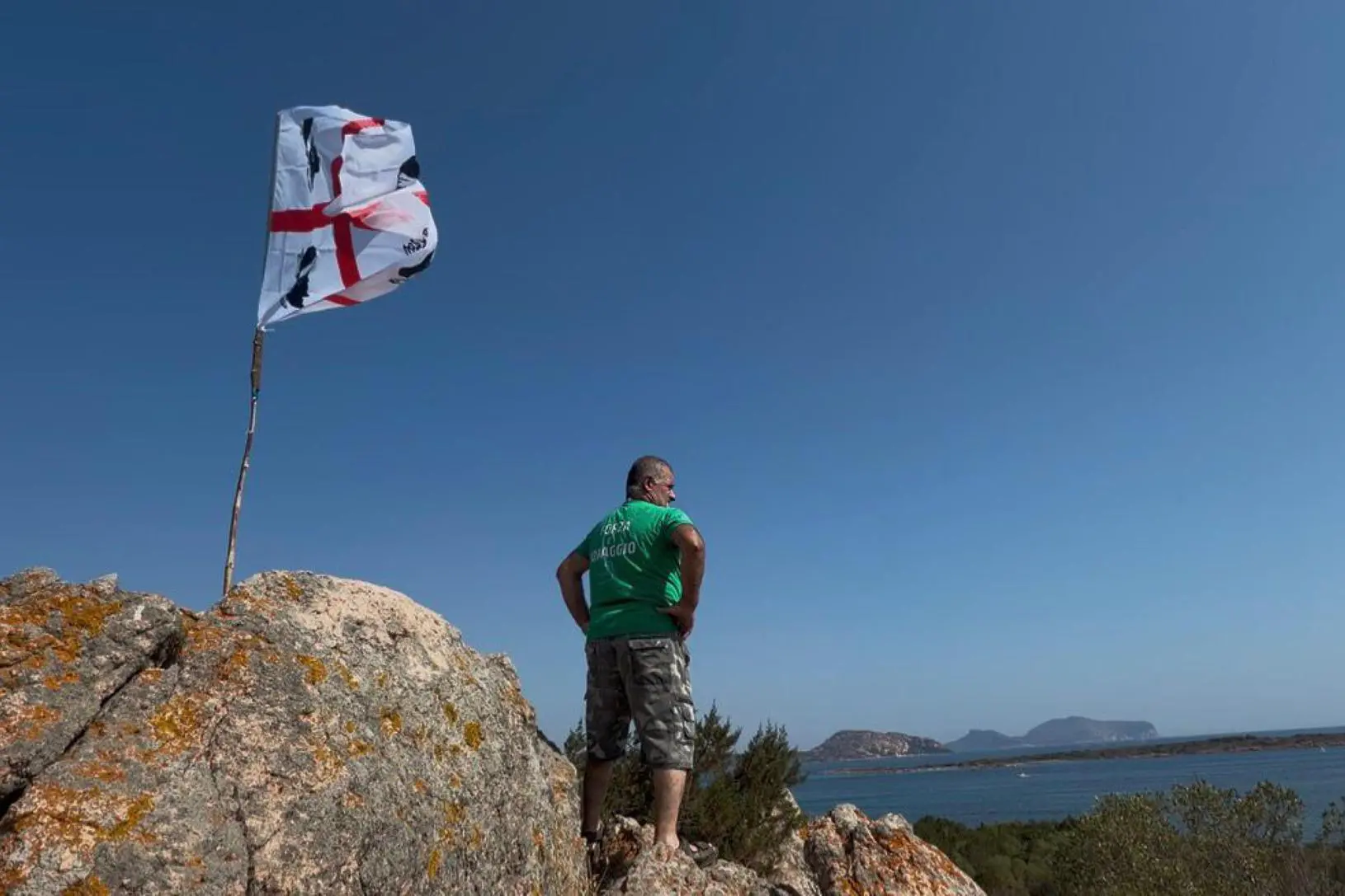 Decine di bandiere dei quattro mori sventolano nello spiazzo dei parcheggi di Cala Finanza, sulla costa nord orientale sarda, a Loiri Porto San Paolo, in Gallura durante il sit-in contro il progetto della società italo brasiliana Tavolara Bay srl, che fa capo al gruppo Jhsf, di realizzare un beach club a cinque stelle con Villa Joy al centro, 1 luglio 2026. ANSA/ ANTONELLA BRIANDA +NPK+
