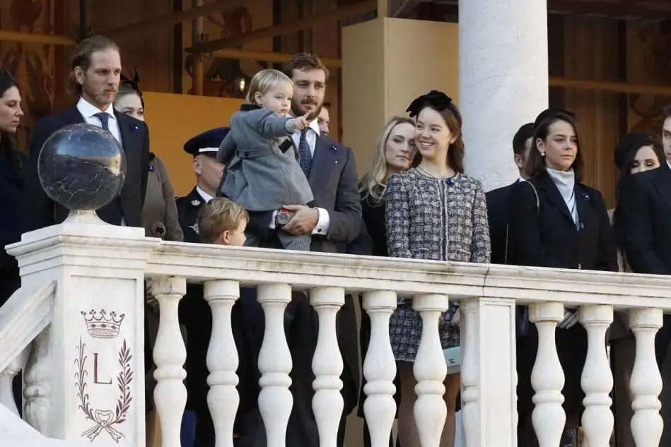 La famiglia reale al balcone: Pierre Casiraghi con il bimbo in braccio, alle sue spalle si intravede la Borromeo (Ansa)