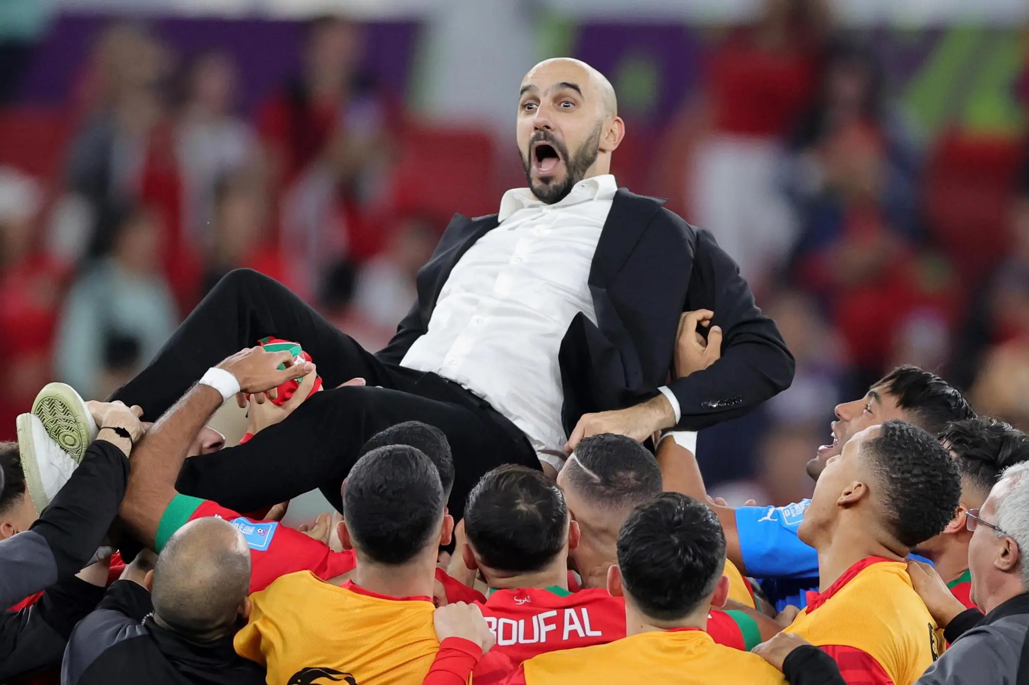epa10359652 Head coach of Morocco, Walid Regragui (up) celebrates winning the FIFA World Cup 2022 quarter final soccer match between Morocco and Portugal at Al Thumama Stadium in Doha, Qatar, 10 December 2022. EPA/Abir Sultan