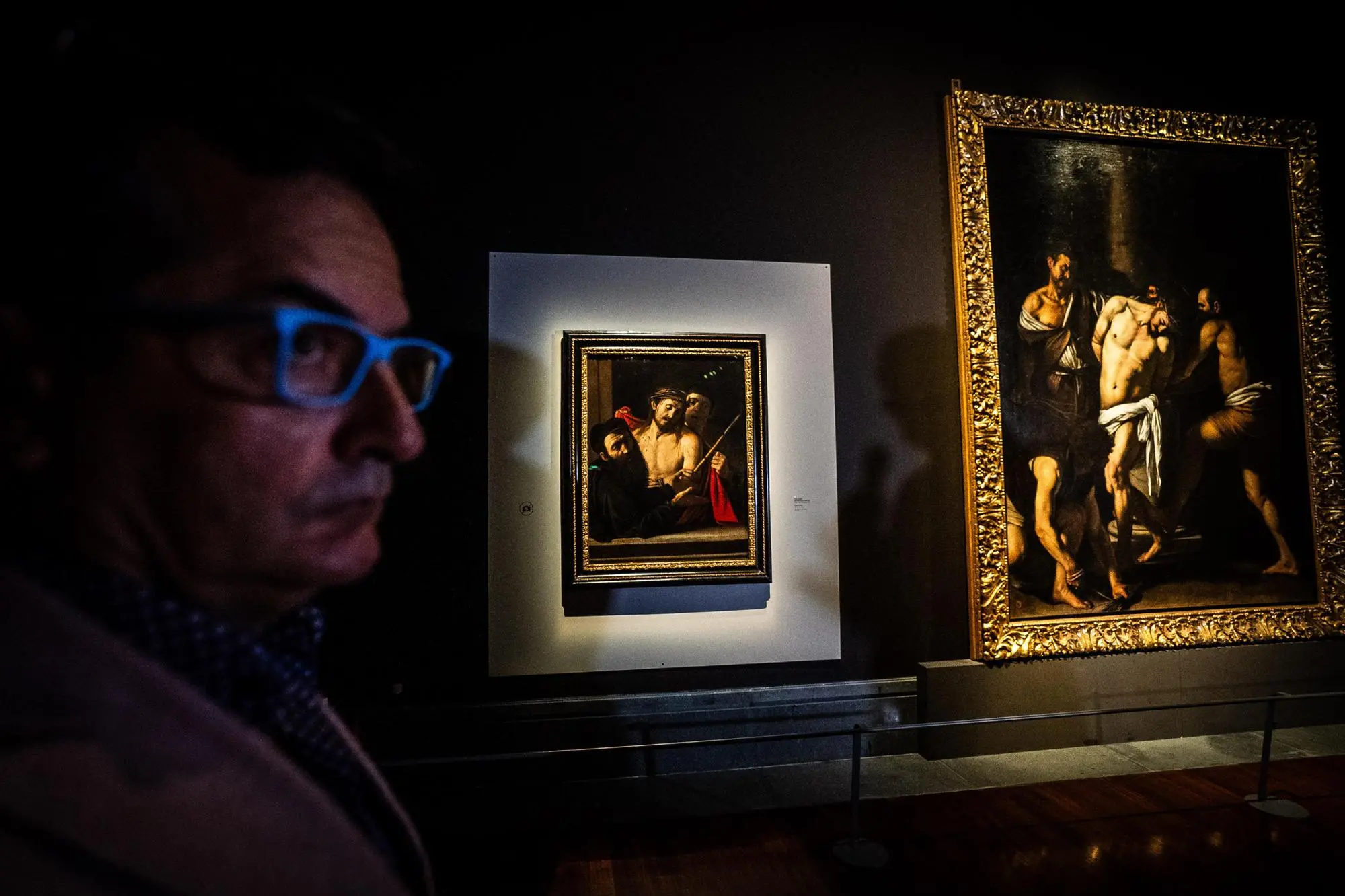 Un visitatore ammira i due quadri di Caravaggio, "Ecce Homo" e "La flagellazione di Cristo" esposti uno vicino all'altro nel Museo Capodimonte di Napoli