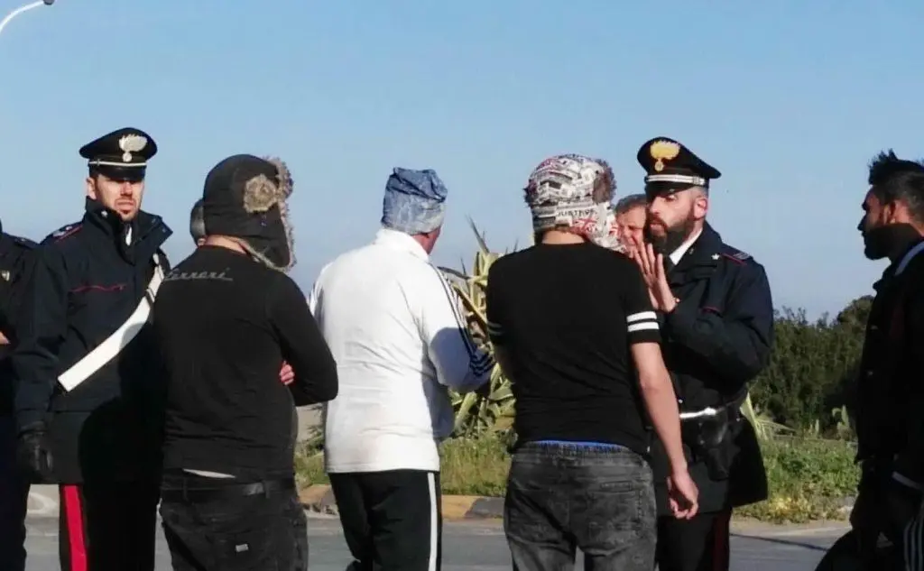 I carabinieri parlano con i migranti dopo lo sbarco