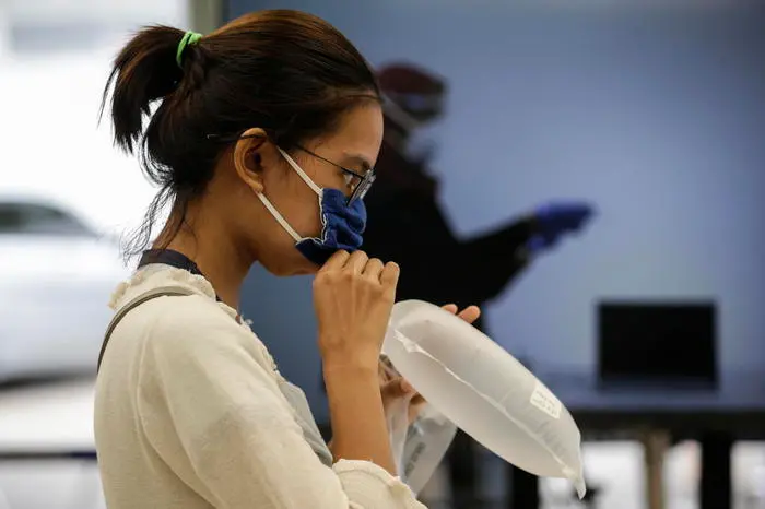 epa08986095 A passenger has her air sample taken to be tested for COVID-19 using a breath detector, GeNose, at Pasar Senen train station in Jakarta, Indonesia, 04 February 2021. GeNose was developed by Gadjah Mada University (UGM) and it was reported to be able to detect COVID-19 cases with an accuracy of 95 percent. EPA/MAST IRHAM