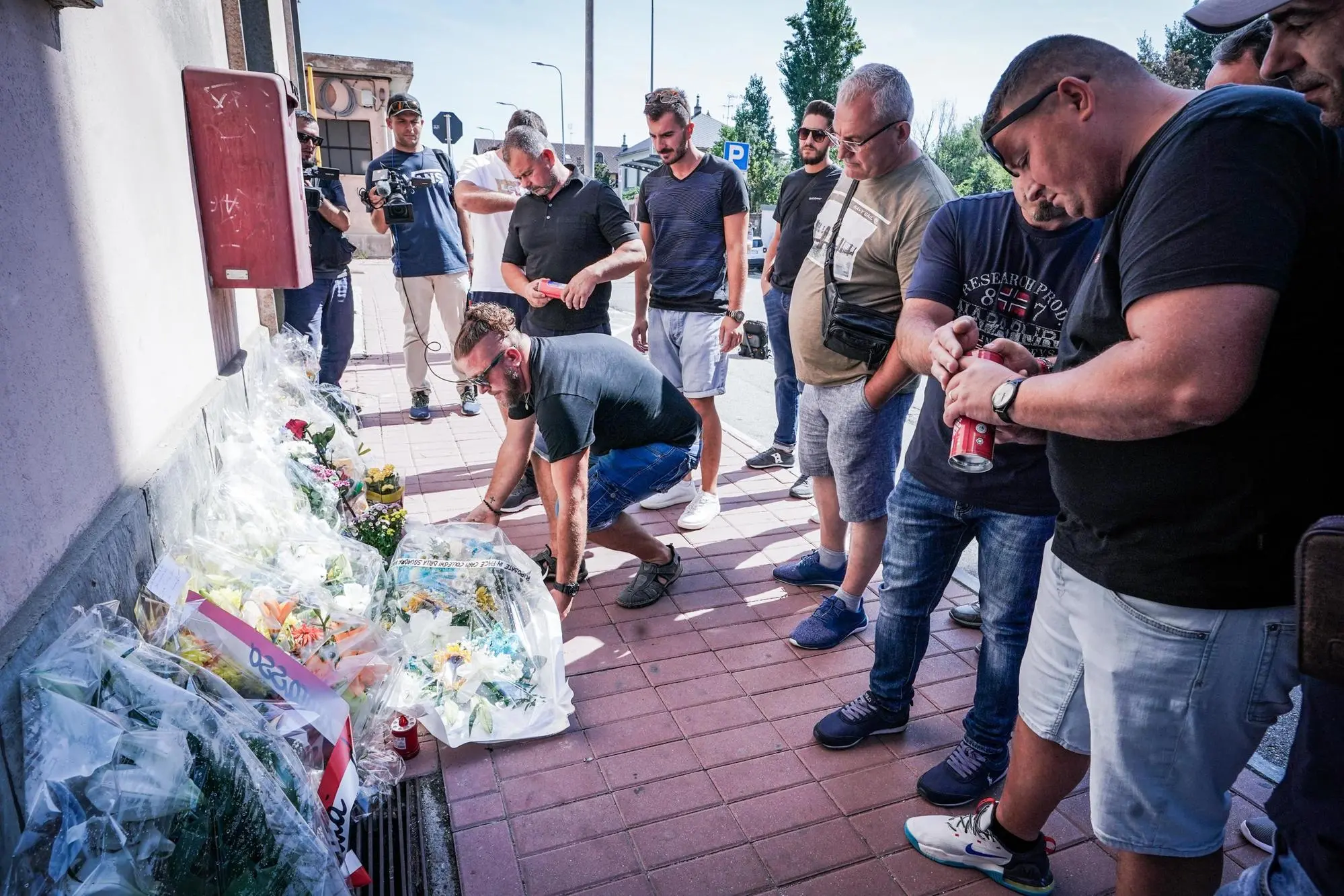 I colleghi di squadra degli operai morti incidente Brandizzo depongono un mazzo di fiori fuori la stazione (Ansa)