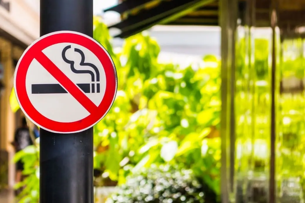 Un cartello che segnala il divieto di fumo all'aperto