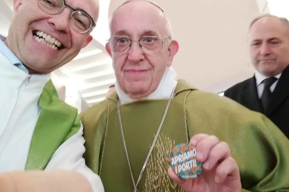 Il Papa con la spilletta che riporta lo slogan "Apriamo i porti" (Ansa)