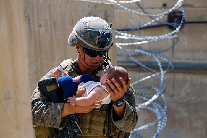 Un Marine con un bambino afghano (Ansa - Epa)