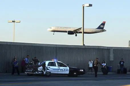 epa03933090 A plane lands as police officers help passengers as flights resumed in and out of Los Angeles International Airport (LAX) after a suspected shooter opened fire in Terminal Three in Los Angeles, California, USA, 01 November 2013. One Transportation Security Administration (TSA) official was killed and a half dozen other people injured during the shooting. The shooter, idetified as 23-year old Paul Ciancia from New Jersey, was injured and taken into custody. EPA/MICHAEL NELSON