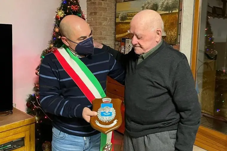 Il sindaco di Florinas, Enrico Lobino, consegna a tiu Battista la targa ricordo per i 100 anni (foto Tellini)