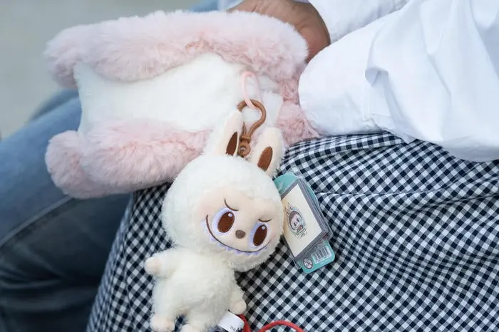 epa12151301 A Labubu doll hangs from a visitor's purse during an organized press tour to Popland, a theme park opened by Chinese toy company Pop Mart, in Beijing, China, 02 June 2025. Labubu is a Nordic-inspired character and collectible plush toy designed by Hong Kong designer Kasing Lung. The dolls have recently gone viral after being worn by celebrities like Rihanna and Due Lipa. EPA/JESSICA LEE