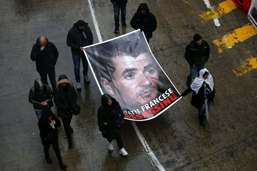 (FILES) In this file photo taken on March 13, 2022 in Bastia, protesters hold a portrait of Yvan Colonna during a rally to pay tribute to the pro-independence activist after he was assaulted in the prison of Arles. - Yvan Colonna, the Corsican independence activist sentenced to life imprisonment for the assassination of prefect Erignac, died on March 21, 2022 in the evening as a result of his attack in Arles prison on March 2, his family told AFP, via his lawyer Patrice Spinosi. (Photo by Pascal POCHARD-CASABIANCA / AFP)
