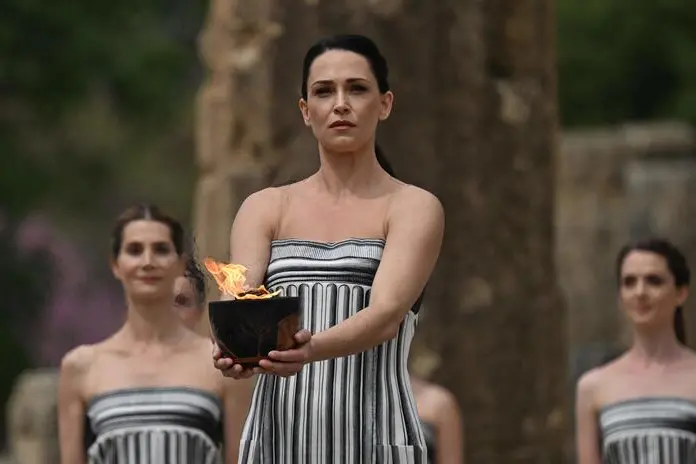 Greek actress Mary Mina, playing the role of the High Priestess, holds the Olympic flame during the flame lighting ceremony for the Paris 2024 Olympics Games at the ancient temple of Hera on the Olympia archeological site, birthplace of the ancient Olympics in southern Greece, on April 16, 2024. (Photo by Aris MESSINIS / AFP)