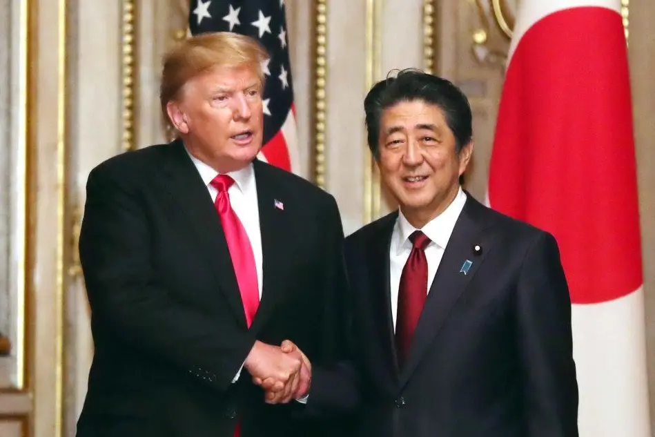 Il presidente Donal Trump stringe la mano al premier giapponese Shinzo Abe (Ansa)
