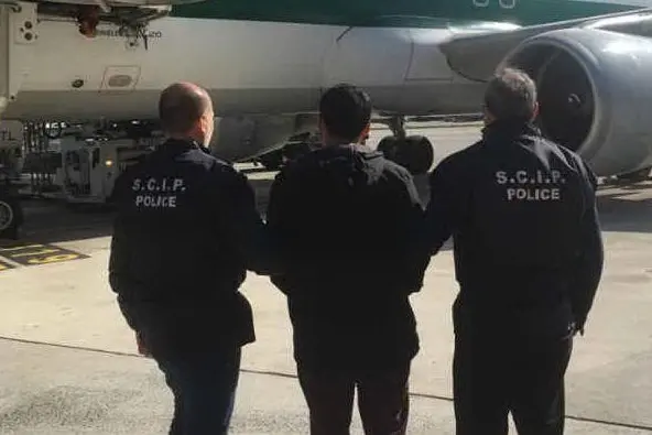 Gli agenti con il 21enne in aeroporto (foto Twitter)