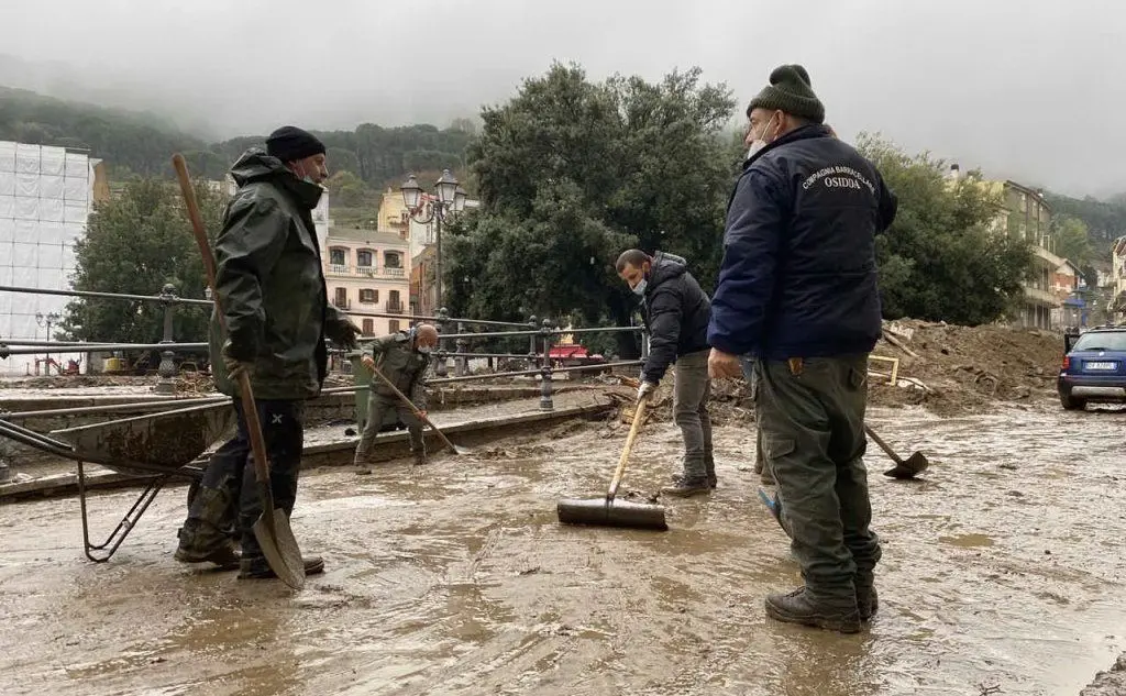 Volontari al lavoro a Bitti dopo l'alluvione (foto archivio L'Unione Sarda)