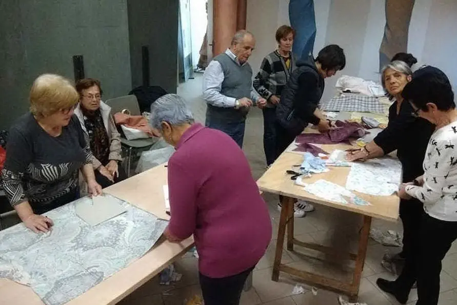 I volontari impegnati nella realizzazione delle banderas de pannu (foto L'Unione Sarda - Ena)