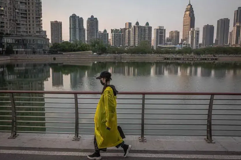 Una ragazza passeggia nel capoluogo dell'Hubei (Ansa)