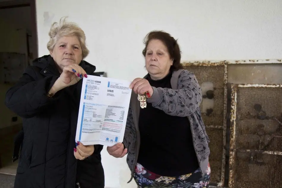 Due condomini mostrano la bolletta di 196mila euro di Abbanoa (foto Fabio Murru)