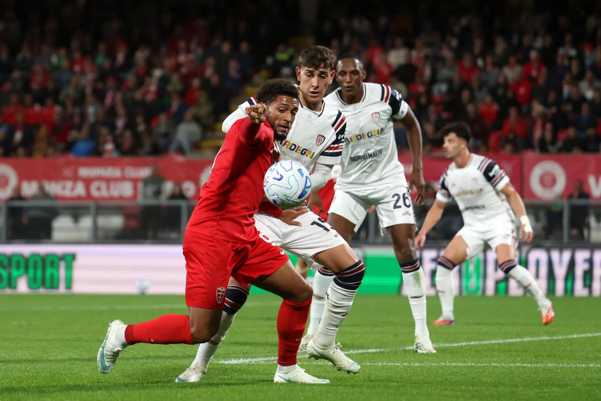 Juan Rodríguez e Yerry Mina provano a contrastare Gustavo Varela, autore di una doppietta in Monza-Cagliari (foto Ansa)