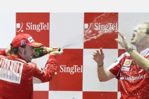 Alonso fa una 'doccia' di champagne al direttore tecnico della Ferrari Aldo Costa dopo la vittoria